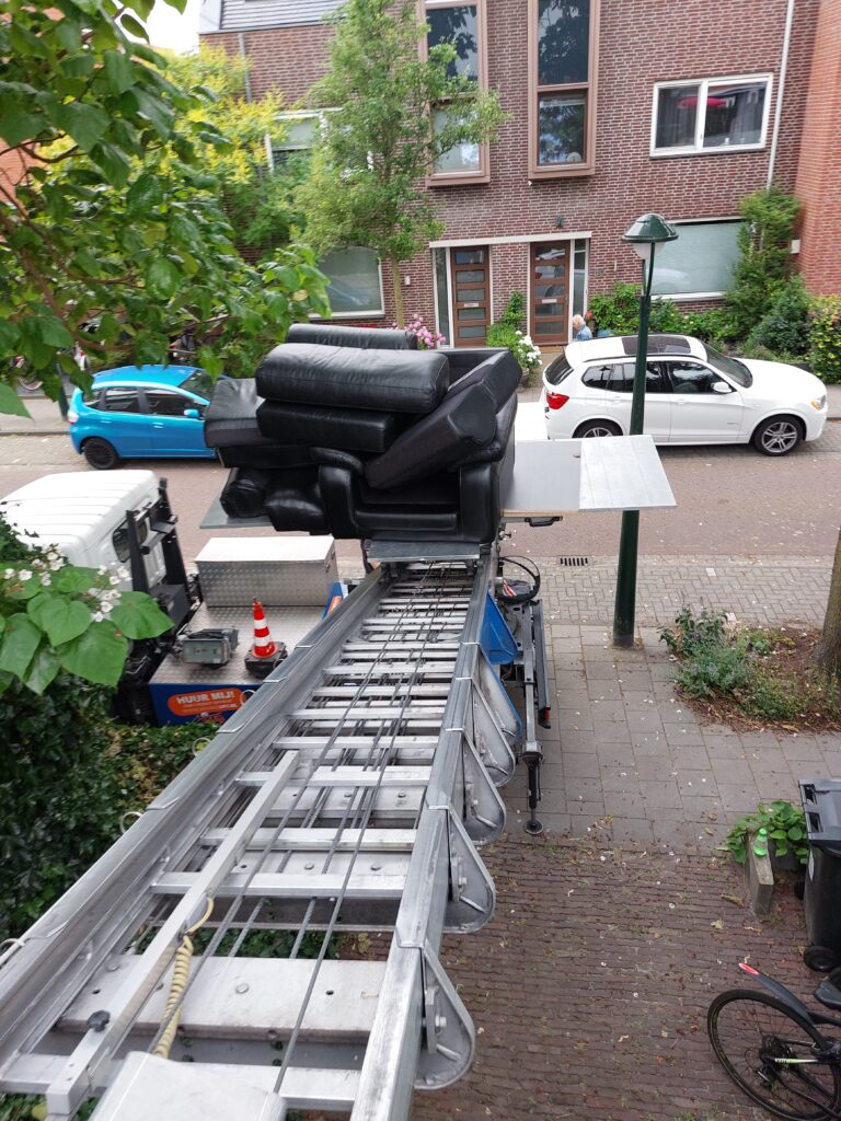 Moving lift carrying a sofa to an upper floor for a high-rise apartment move. Seeing how the moving furniture lift works in action.