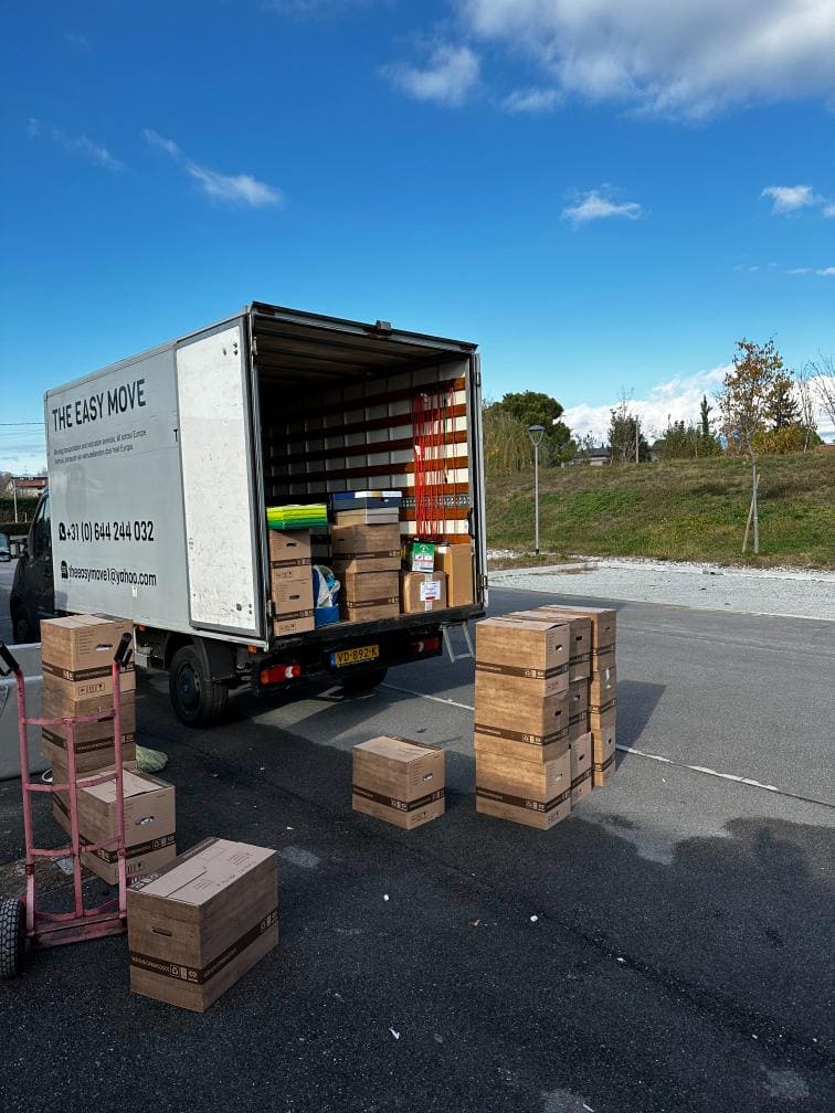 Cardboard boxes filled with belongings being loaded and unloaded by movers in Besançon